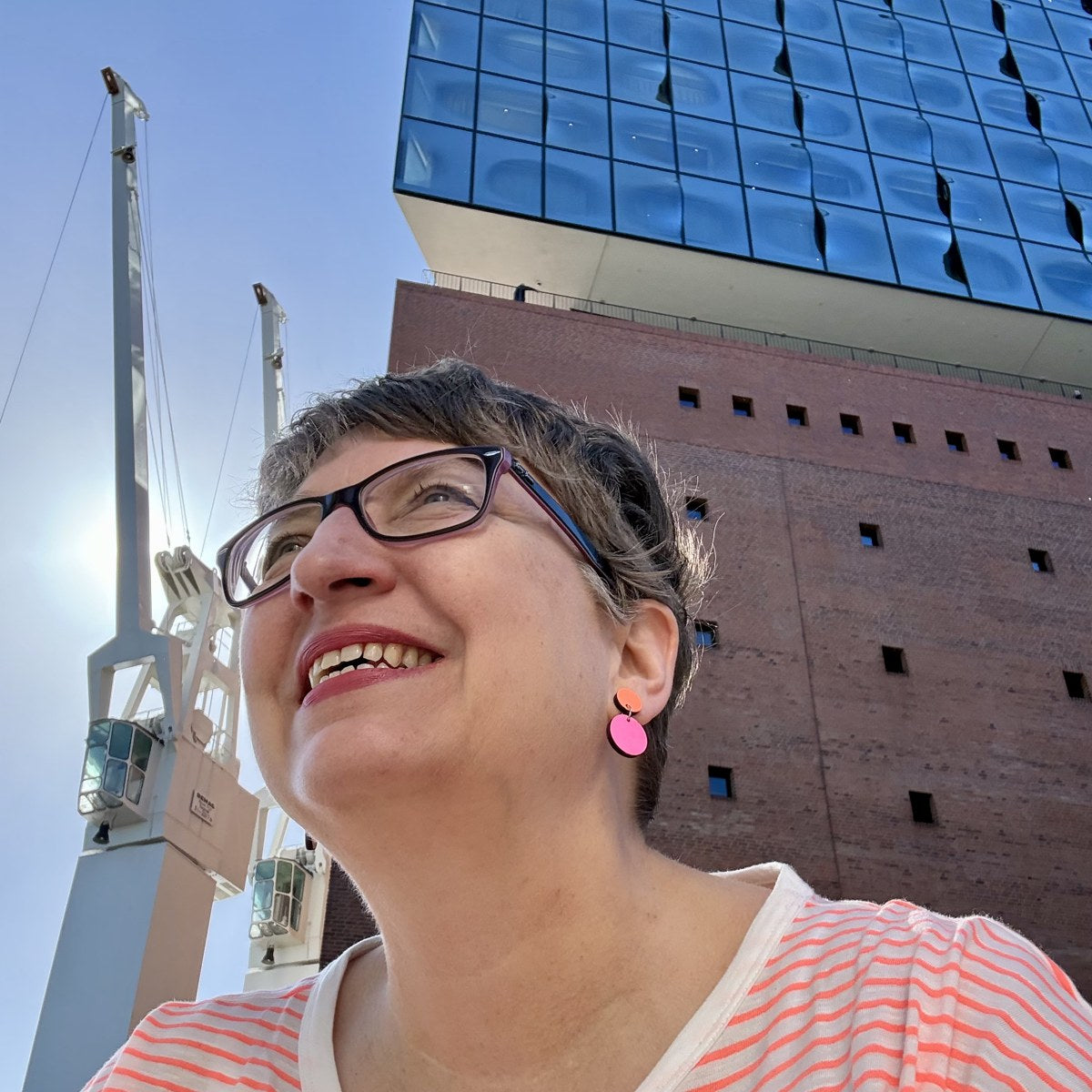 Iris mit pinken Ohrhängern vor der Elbphilharmonie in Hamburg