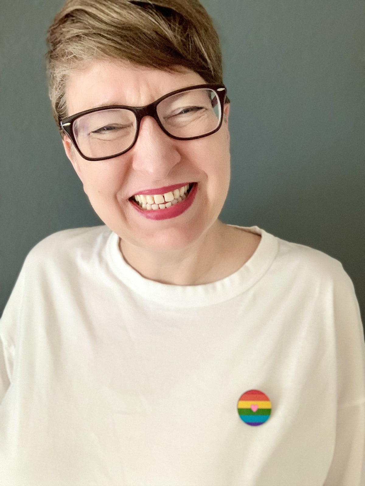 Iris von Little Hamburg Lab trägt die Regenbogen-Brosche am weißen Shirt