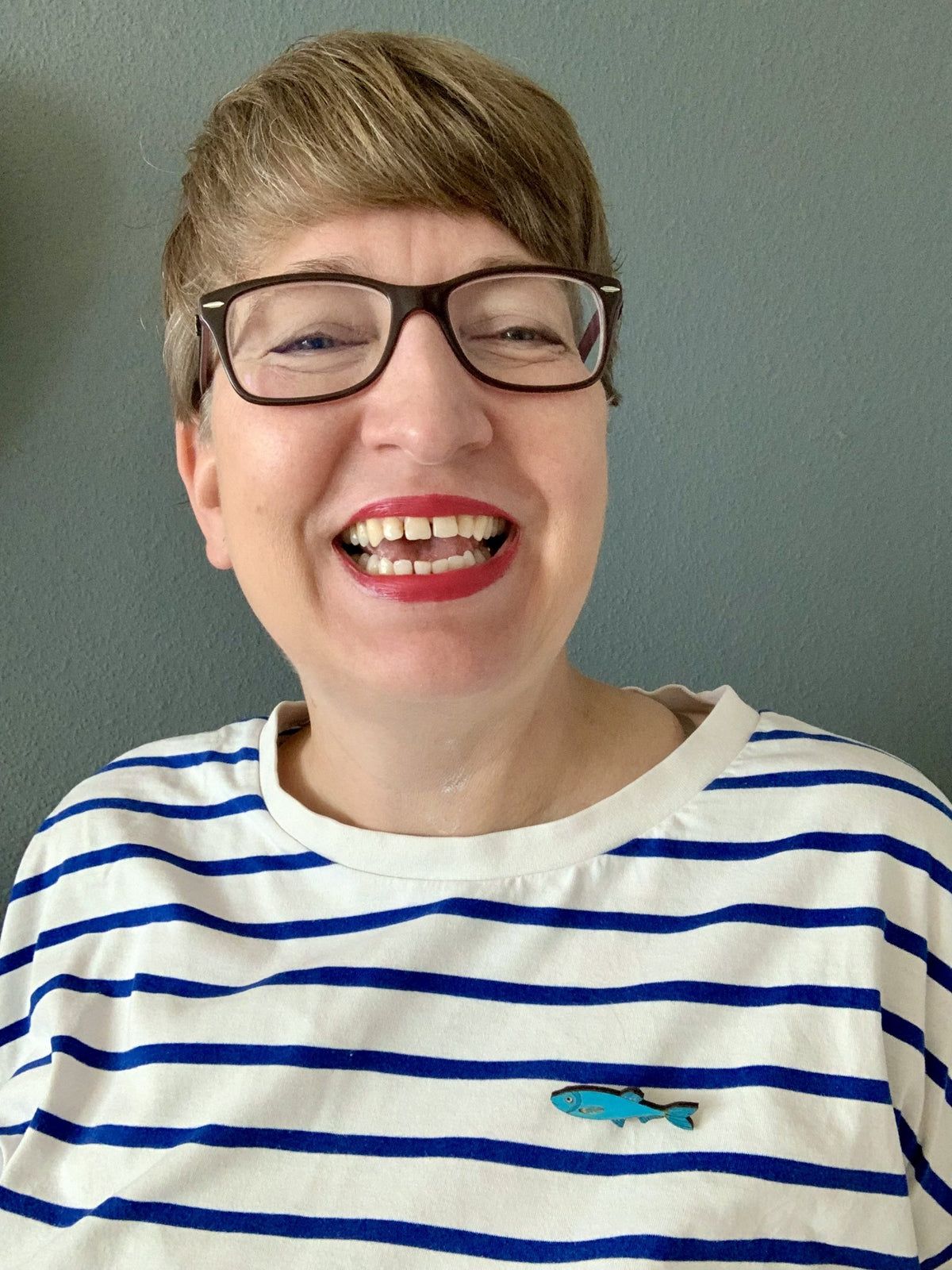 Blaue Sprotten-Brosche getragen am gestreiften Shirt